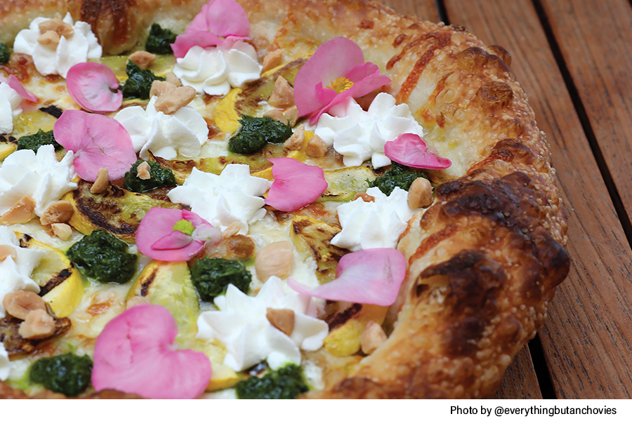 Summer's Bounty Pizza with edible flowers, salsa verde, Marcona almonds, ricotta and goat cheese mixture, roasted yellow squash
