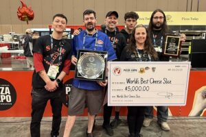 Chris Ostapenko of Slice on Broadway in Pittsburgh celebrates his World’s Best Cheese Slice Championship win with team mates at International Pizza Challenge at Pizza Expo in Las Vegas.