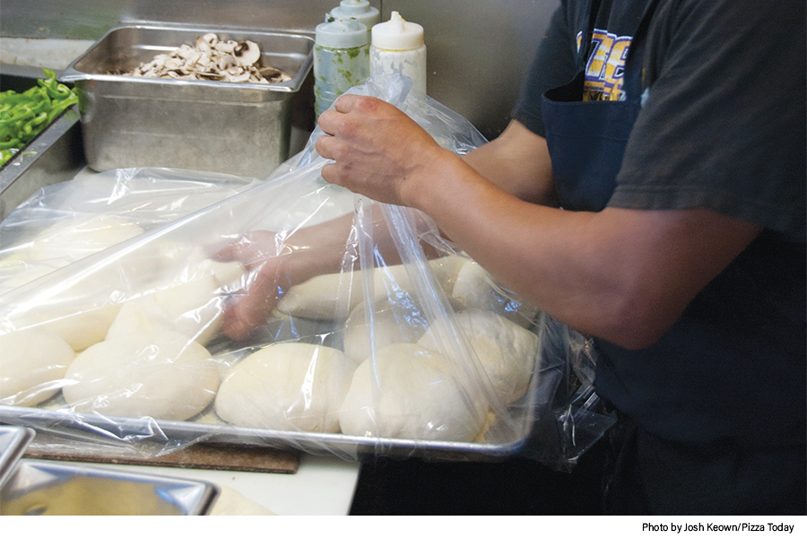 pulling pizza dough from wrap