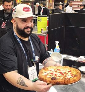 Image of Wilhelm Rodriguez holding his award-winning pizza.